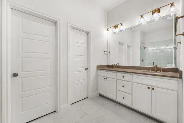 a bathroom with a granite countertop sink double and mirror