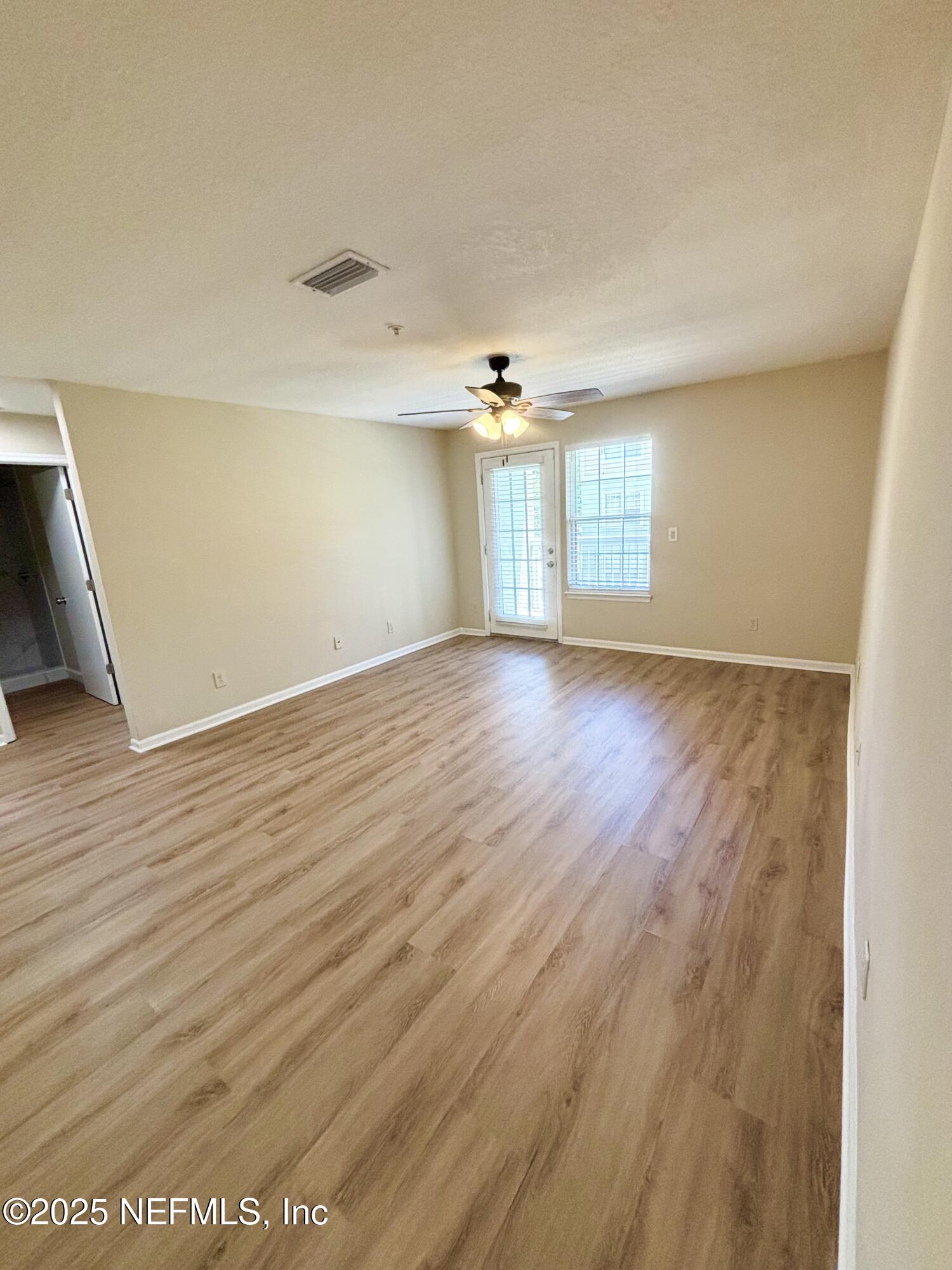 7701 Timberlin Park Boulevard, Unit 322 Jacksonville, FL 32256 - Photo 18 of 31 an empty room with wooden floor and windows