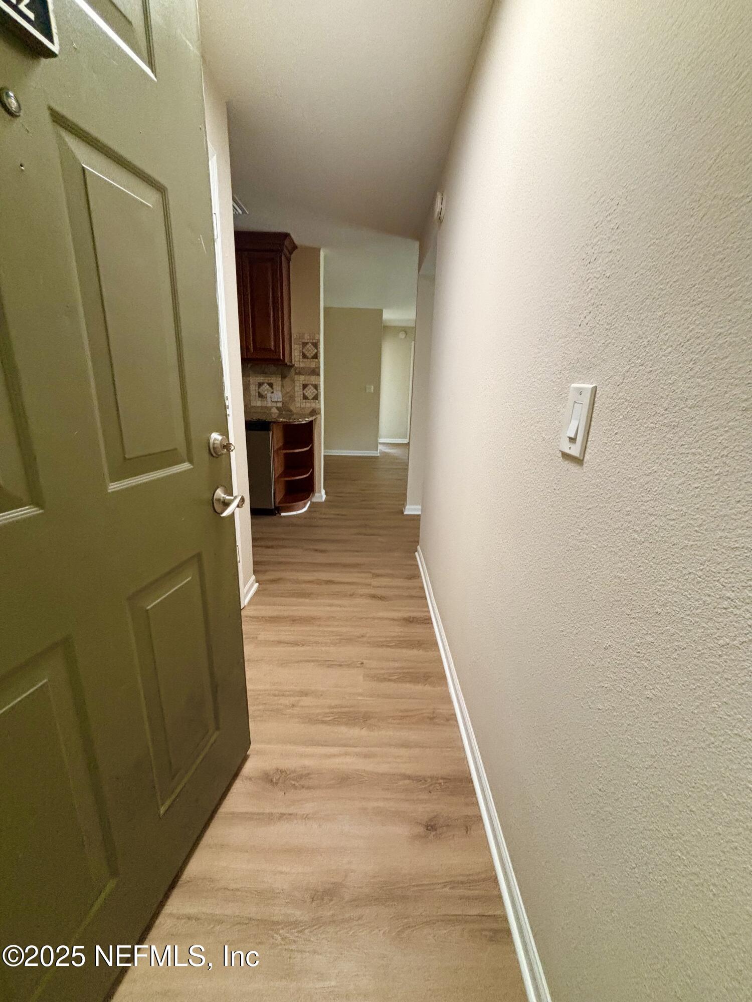 7701 Timberlin Park Boulevard, Unit 322 Jacksonville, FL 32256 - Photo 9 of 31 a view of a hallway with wooden floor and staircase