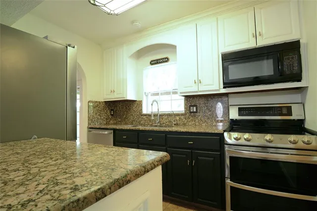 a kitchen with granite countertop a stove and a sink