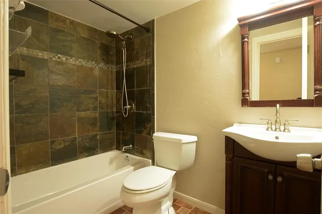a bathroom with a sink mirror toilet and bathtub