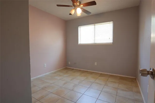 an empty room with a window and a fan