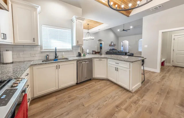 a kitchen with a sink cabinets and wooden floor
