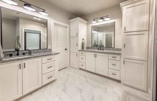a spacious bathroom with a granite countertop sink and a mirror
