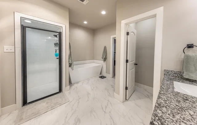 a bathroom with a granite countertop shower toilet and sink