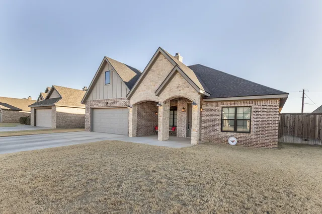 a view of a house with a yard and garage