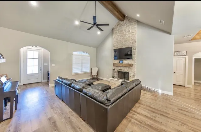 a living room with fireplace furniture and a wooden floor