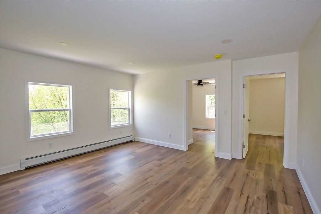 165 Sandisfield Road Sandisfield, MA 01255 - Photo 24 of 37 an empty room with wooden floor and windows