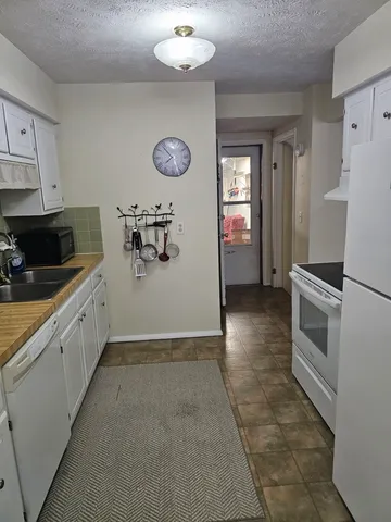 a kitchen with a refrigerator and a stove top oven