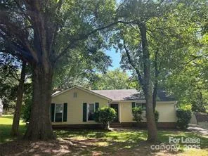 a white house that has a tree in front of it