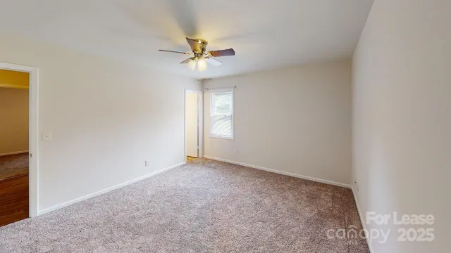 an empty room with a window and a fan