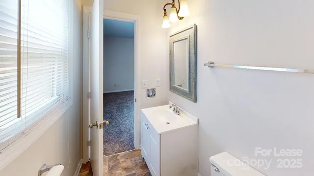 a bathroom with a sink and mirror with toilet