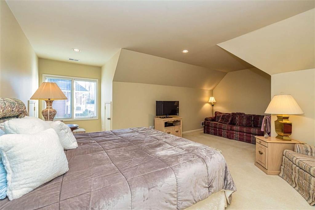 35 Torrey Pines Court Newnan, GA 30265 - Photo 30 of 54 a spacious bedroom with a large bed and a flat tv screen on dresser