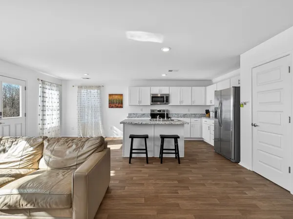 a living room with stainless steel appliances kitchen island granite countertop furniture and a couch
