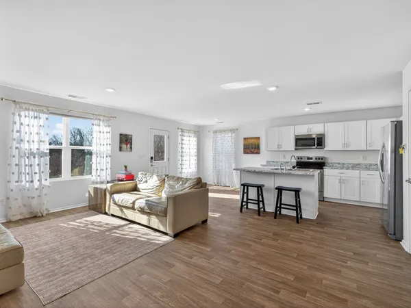 a living room with furniture and a kitchen