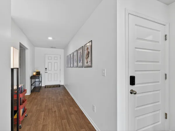 a view of a hallway with wooden floor and closet