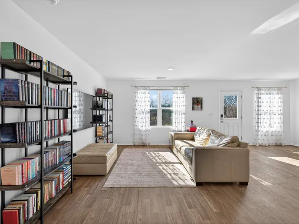 a living room with furniture and a book shelf