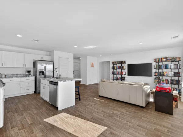 a living room with furniture and kitchen view