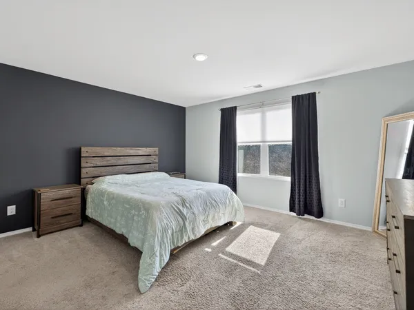 a bedroom with a large bed and a window