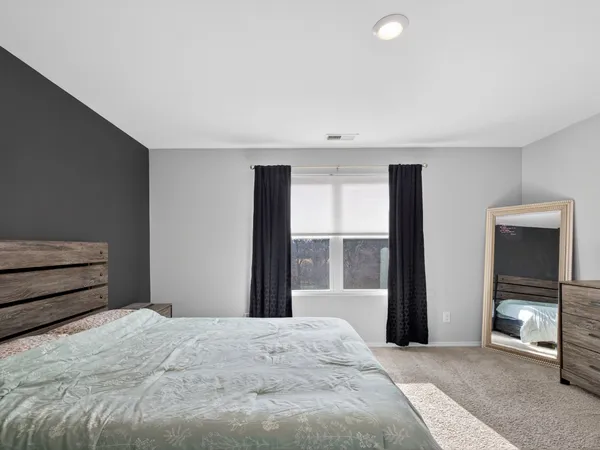 a bedroom with a bed and a large window