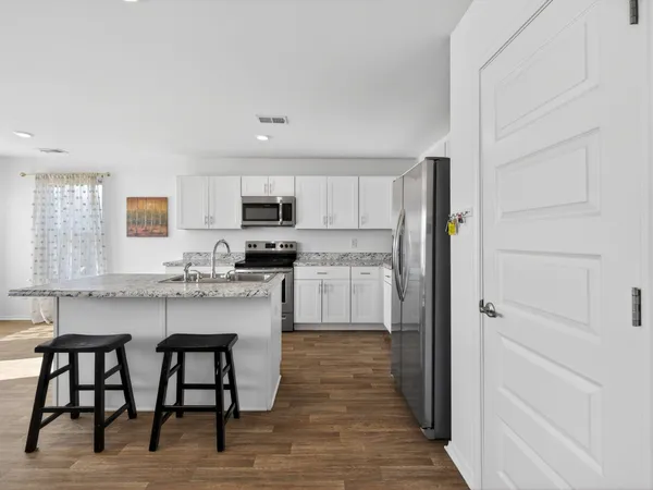 a kitchen with white cabinets and stainless steel appliances