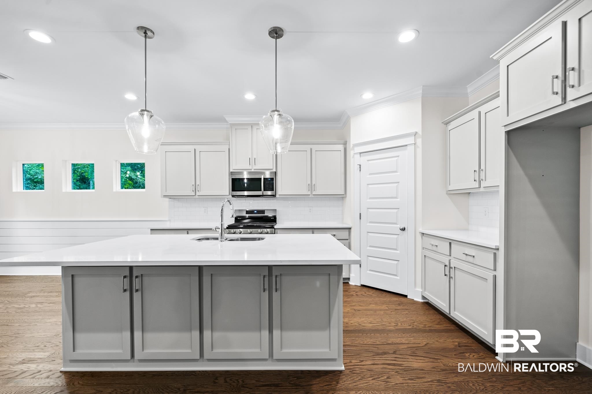 29 Signal Hill Road Daphne, AL 36527 - Photo 9 of 36 Kitchen featuring hanging light fixtures, stainless steel appliances, white cabinetry, sink, and dark wood-type flooring