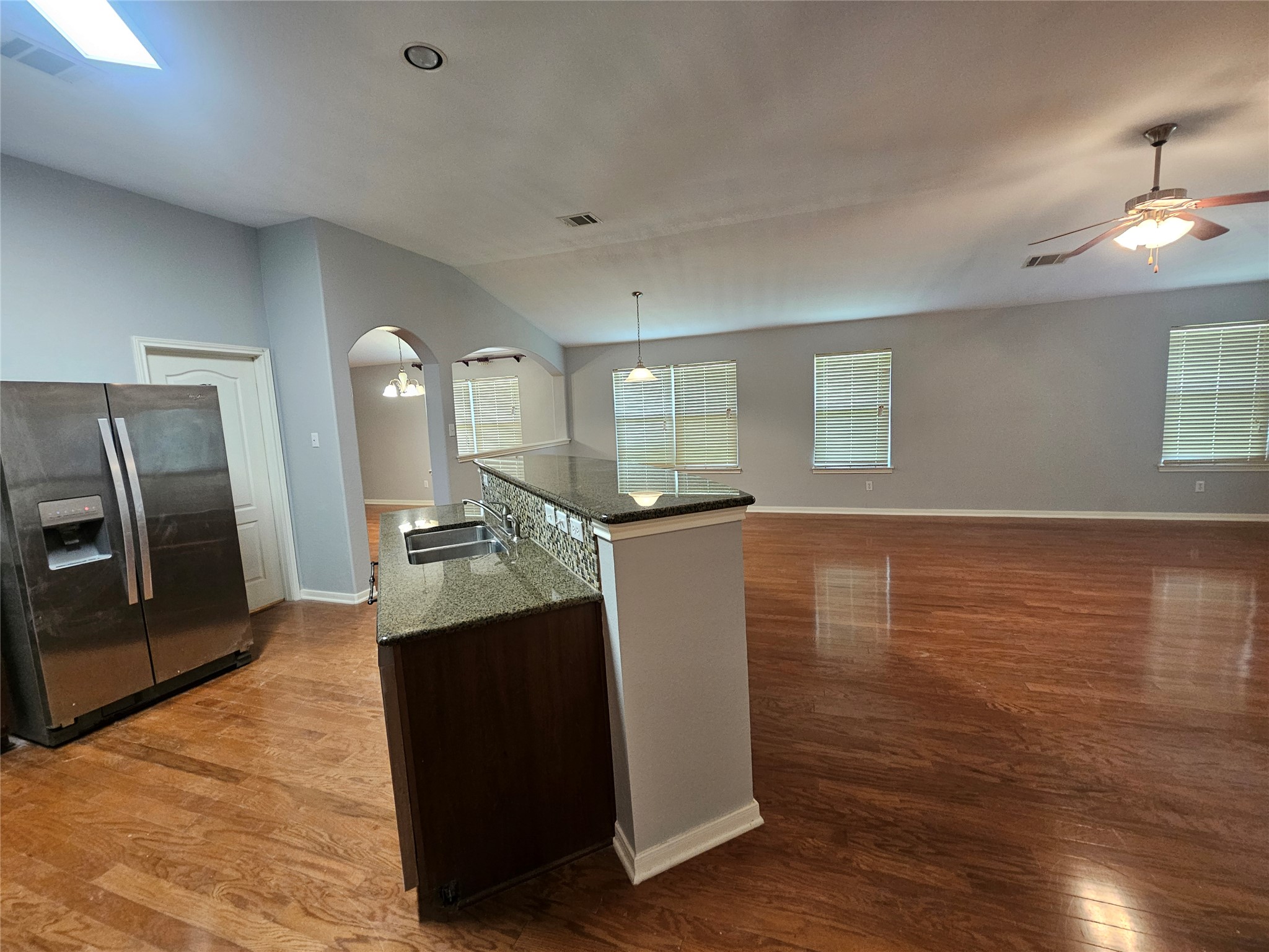 2035 Intrepid Drive Buda, TX 78610 - Photo 21 of 26 An open-concept living space with polished hardwood flooring connects kitchen and living areas seamlessly.
