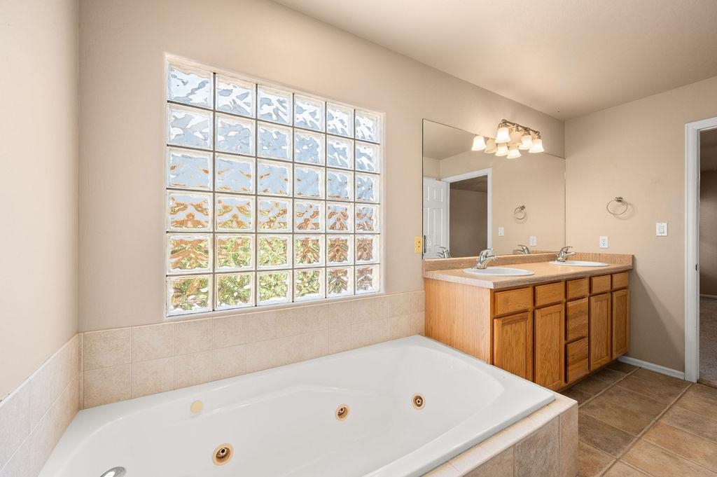 710 Comstock Drive Fruita, CO 81521 - Photo 11 of 25 a bathroom with a tub a sink and a large window