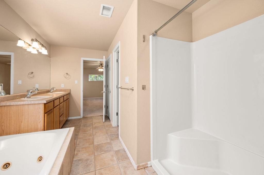 710 Comstock Drive Fruita, CO 81521 - Photo 12 of 25 a large bathroom with a tub a sink and a mirror