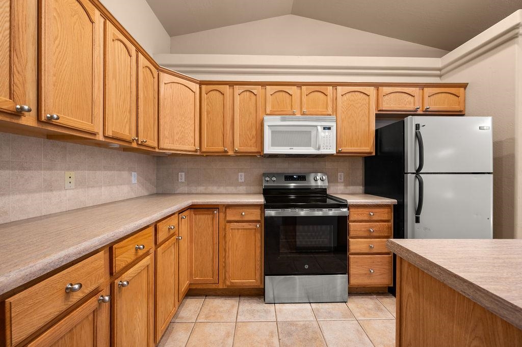 710 Comstock Drive Fruita, CO 81521 - Photo 6 of 25 a kitchen with stainless steel appliances granite countertop a refrigerator and a stove