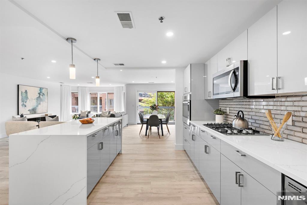 302 Smith Court Edgewater, NJ 07020 - Photo 11 of 34 a kitchen with stainless steel appliances kitchen island granite countertop a sink and cabinets
