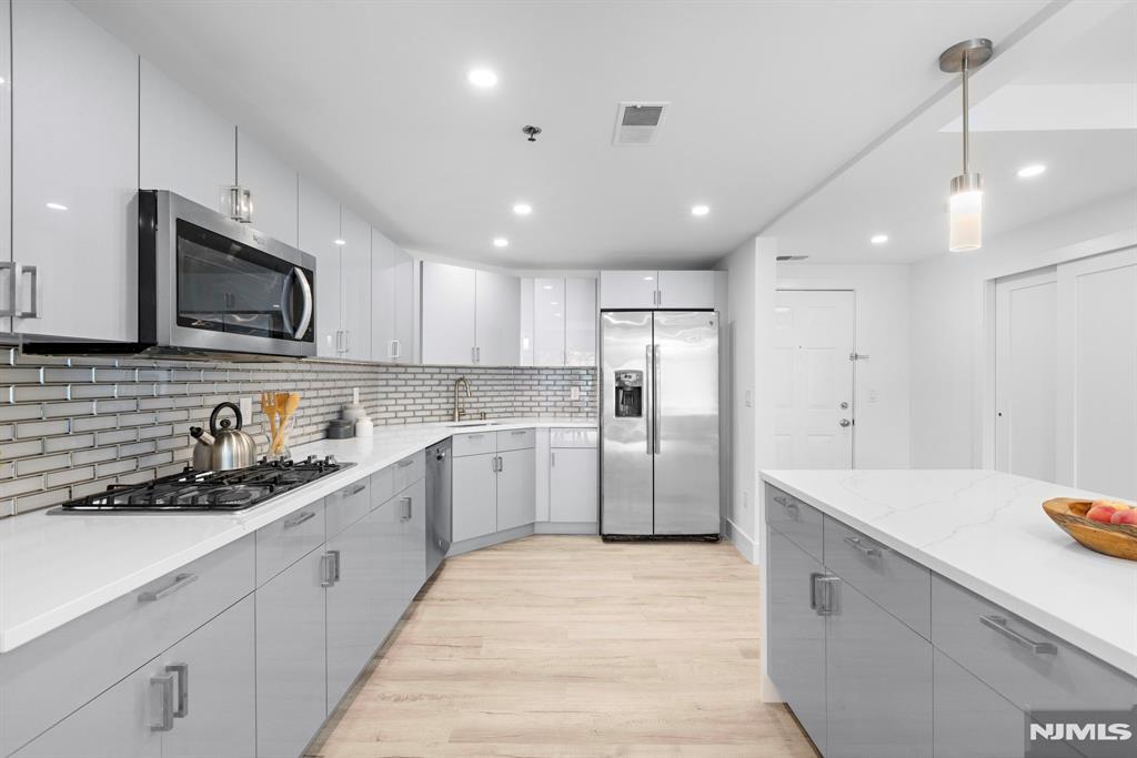 302 Smith Court Edgewater, NJ 07020 - Photo 12 of 34 a kitchen with a sink stainless steel appliances and cabinets