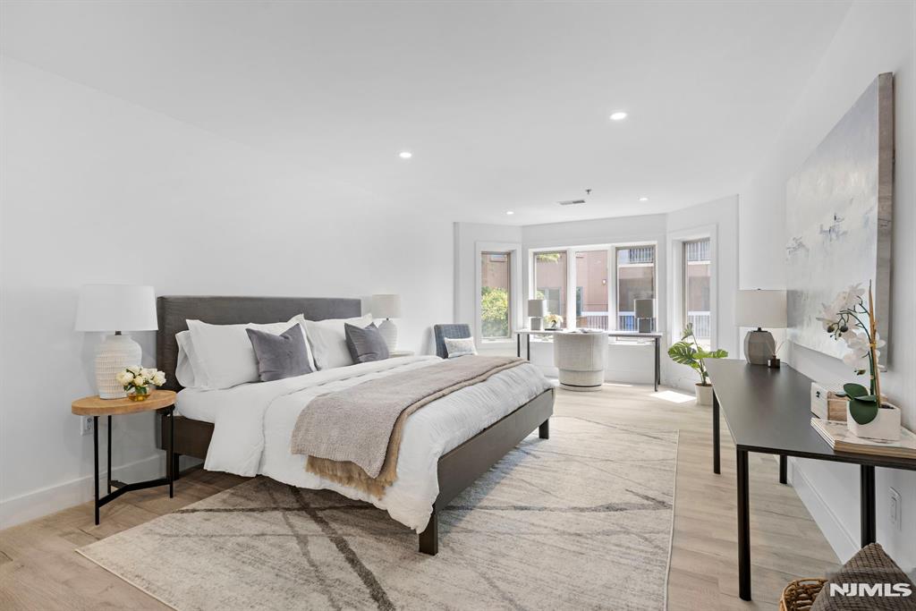 302 Smith Court Edgewater, NJ 07020 - Photo 18 of 34 a spacious bedroom with a bed and a table