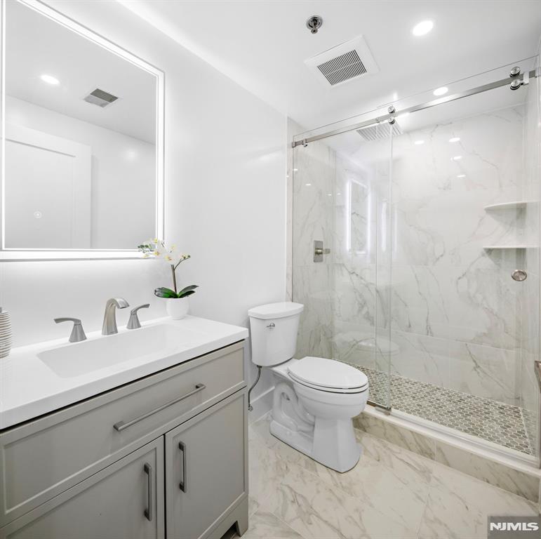 302 Smith Court Edgewater, NJ 07020 - Photo 24 of 34 a bathroom with a sink toilet vanity and shower