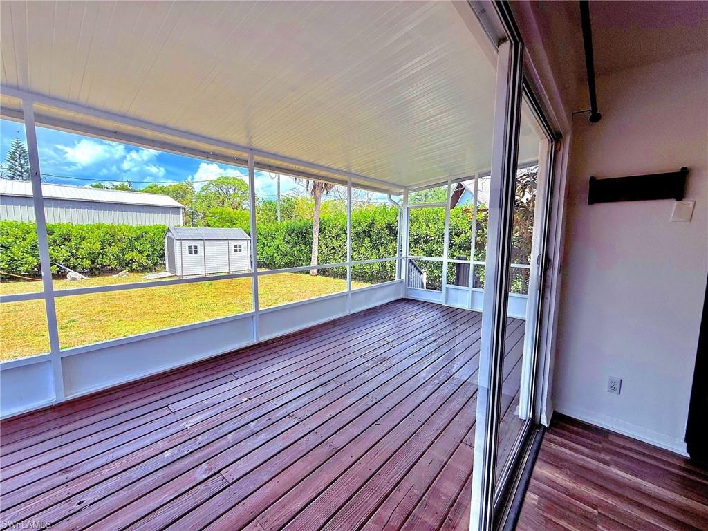 4211 Cindy Avenue Naples, FL 34112 - Photo 11 of 26 a view of an empty room with wooden floor and a outdoor space