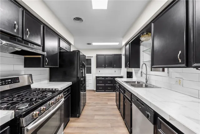a kitchen with stainless steel appliances a sink stove and refrigerator