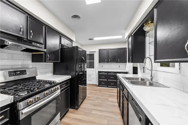 a kitchen with stainless steel appliances granite countertop a sink stove and refrigerator