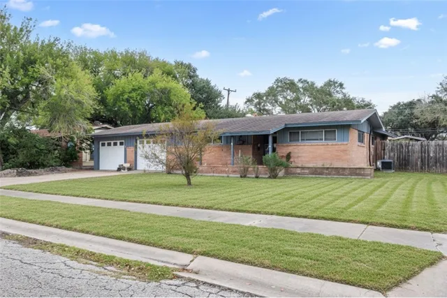 a front view of a house with a yard and trees