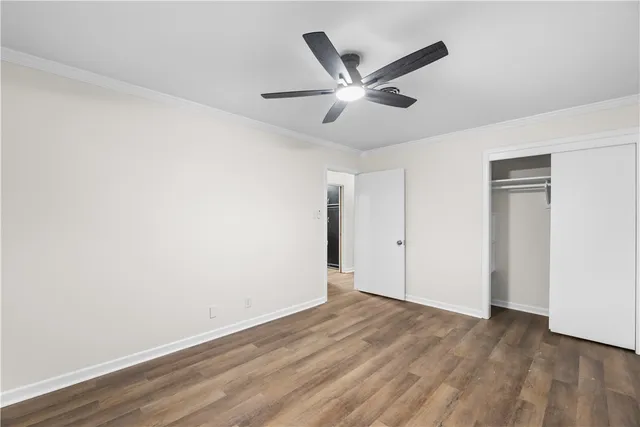 a view of a big room with wooden floor closet and windows
