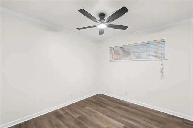 an empty room with wooden floor and ceiling fan