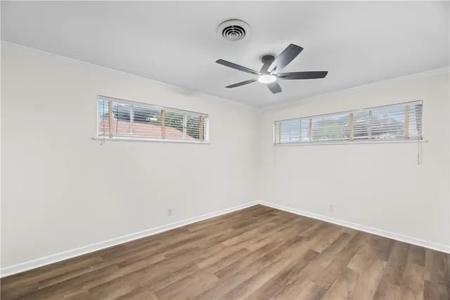 a view of empty room with wooden floor