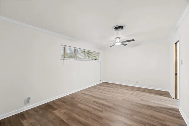 a view of a room with wooden floor and ceiling fan