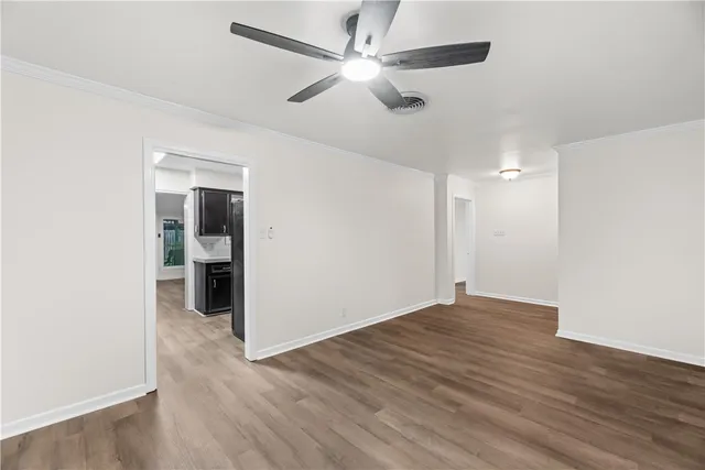 a view of an empty room with wooden floor
