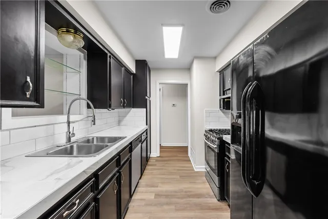 a kitchen with granite countertop a sink and stainless steel appliances