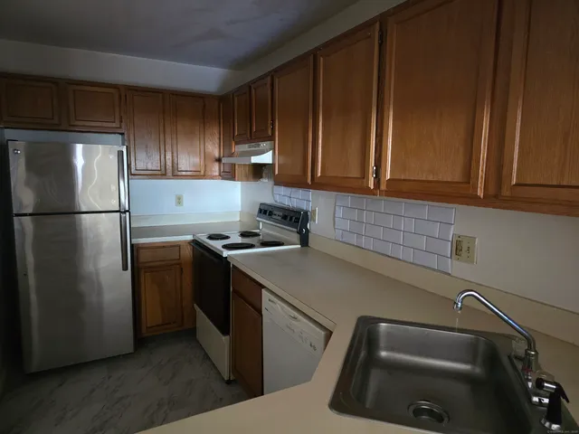 a kitchen with a refrigerator sink and cabinets