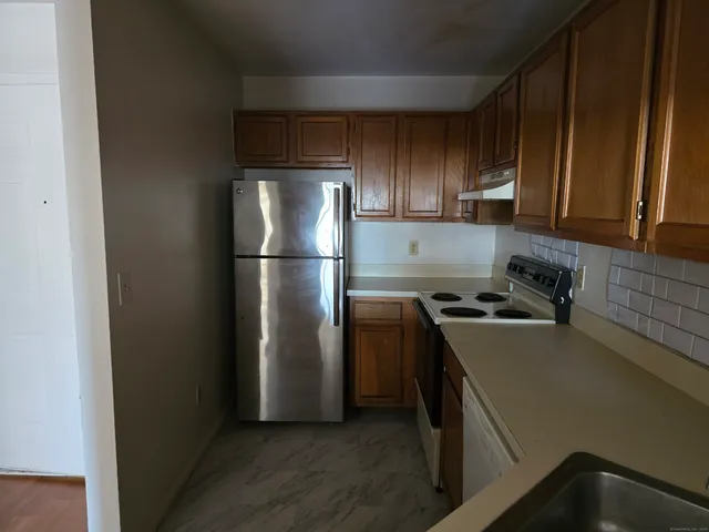 a kitchen with a refrigerator sink and cabinets