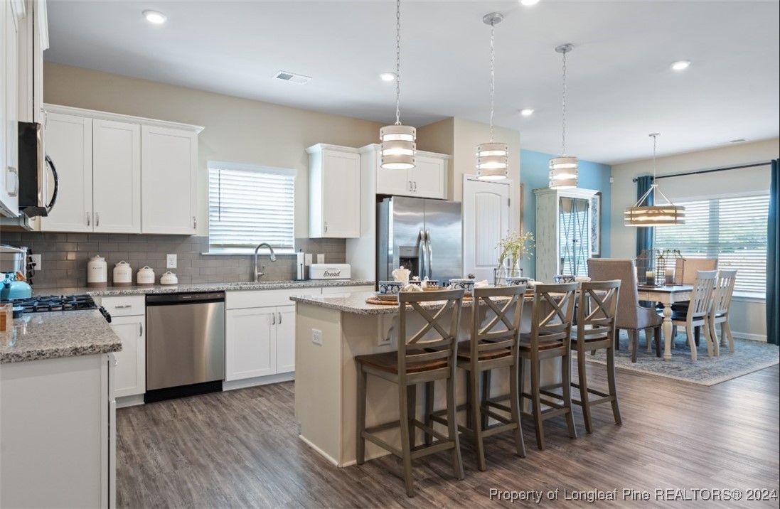 1594 Old Barn Road Fayetteville, NC 28312 - Photo 11 of 18 a kitchen with cabinets a sink counter and chairs
