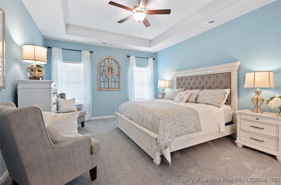 1594 Old Barn Road Fayetteville, NC 28312 - Photo 15 of 18 a spacious bedroom with a bed and a chandelier
