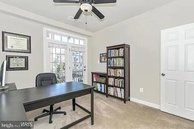 a view of a workspace with furniture and a window