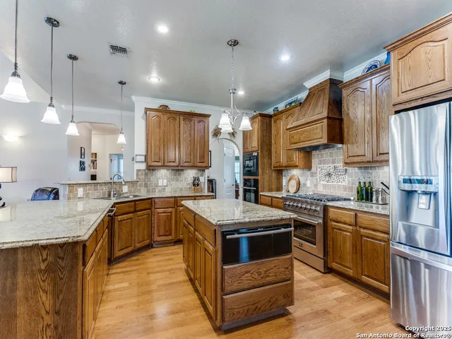 a kitchen with stainless steel appliances granite countertop a sink stove and refrigerator